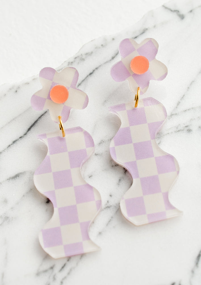 A pair of purple checker print earrings in wavy flower shape.