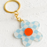 Sky Blue Multi: A flower shaped keychain in sky blue checker print with red center.