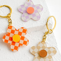 2: Three flower shaped keychains in checkerboard pattern in assorted colors.