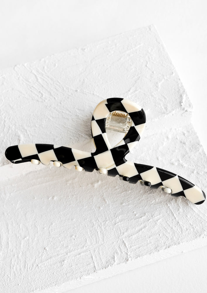 A butterfly hair clip made from resin with black and white checkered pattern.