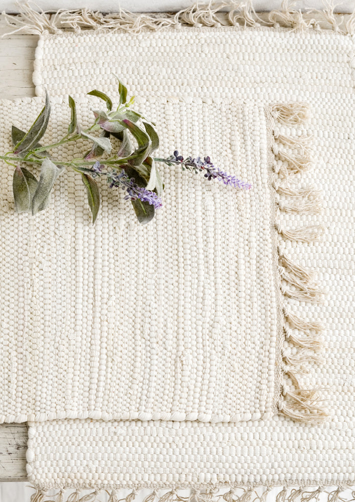 Two chindi weave placemats in ivory with tonal fringed trim.