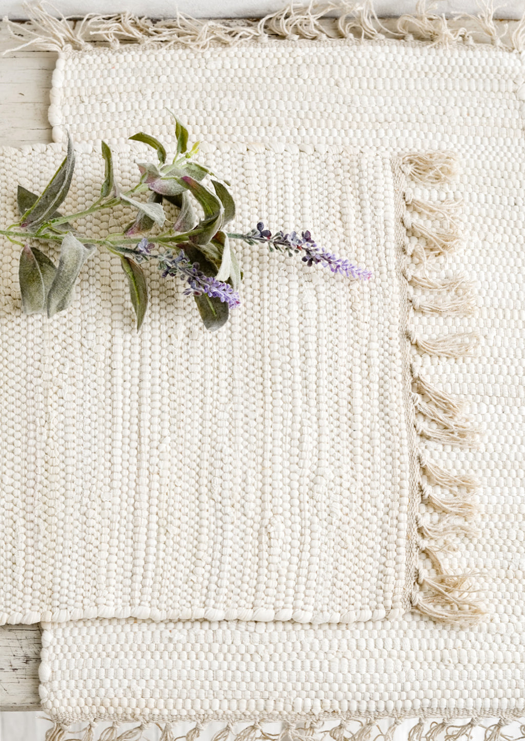 1: Two chindi weave placemats in ivory with tonal fringed trim.