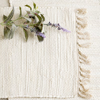1: Two chindi weave placemats in ivory with tonal fringed trim.