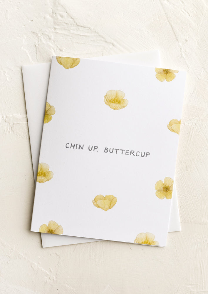A greeting card with images of buttercups, text reads "chin up buttercup".