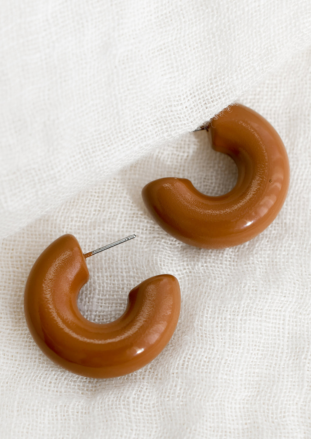 Cocoa: A pair of chunky gloss finish hoop earrings in chocolate brown.