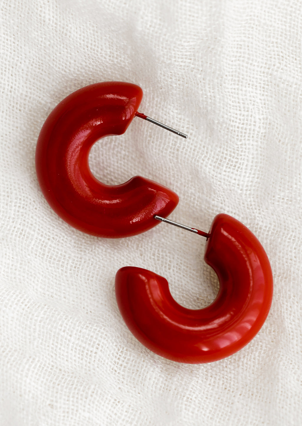 Crimson: A pair of chunky gloss finish hoop earrings in crimson red.