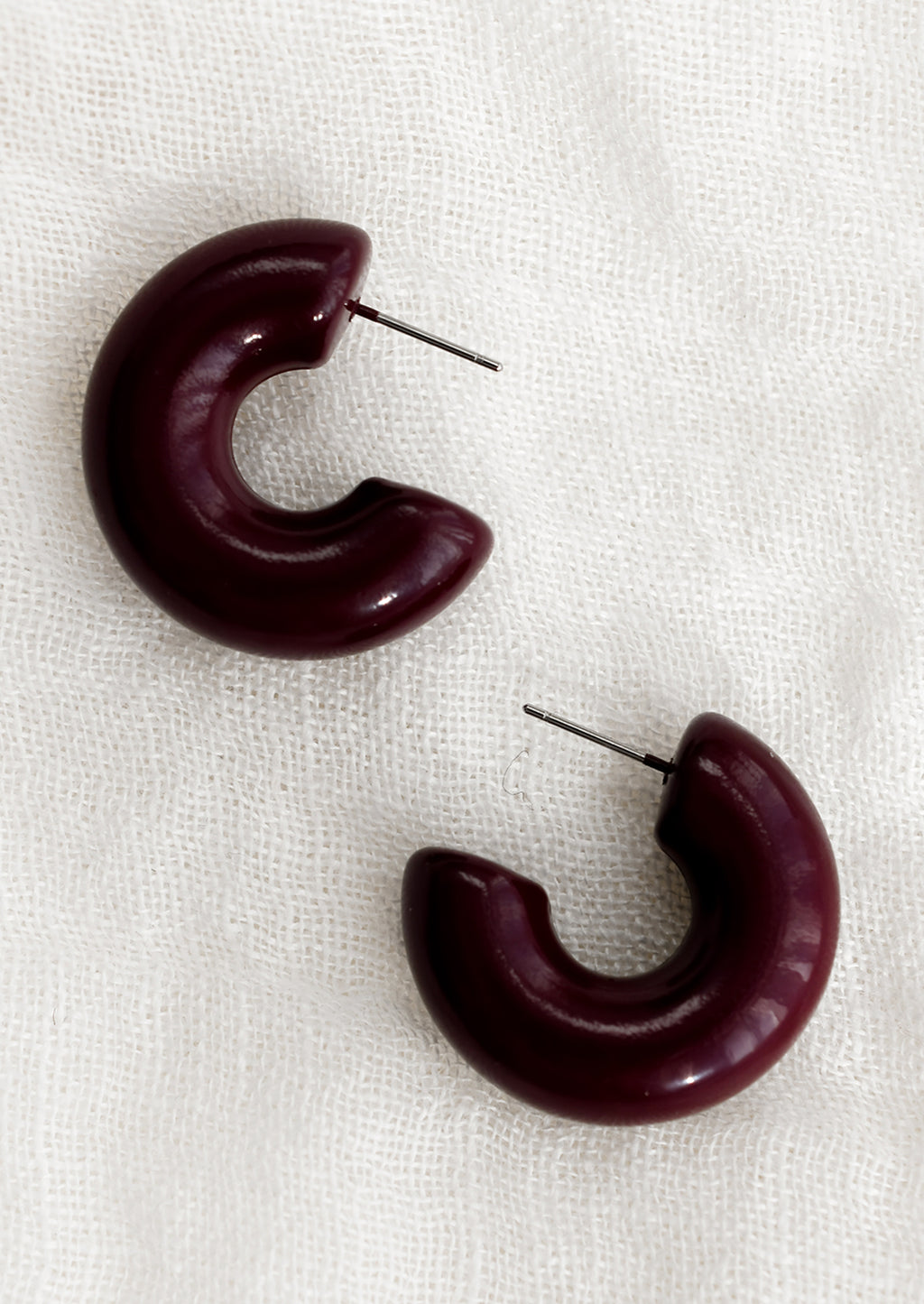 Raisin: A pair of chunky gloss finish hoop earrings in raisin purple-brown.