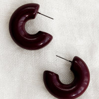 Raisin: A pair of chunky gloss finish hoop earrings in raisin purple-brown.