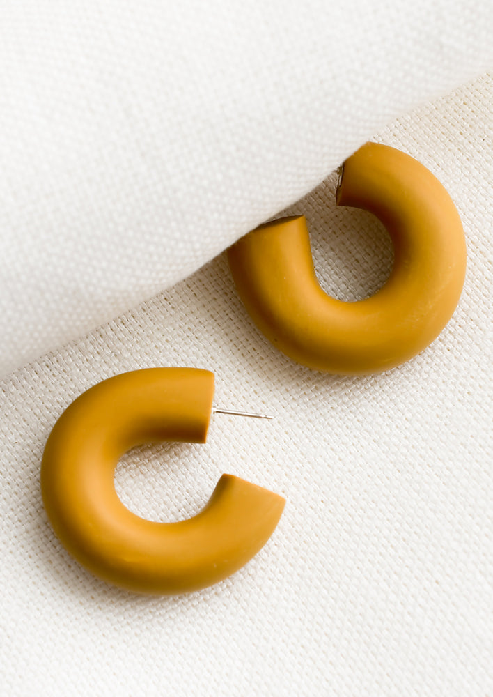 A pair of polymer clay hoop earrings in dulce brown.