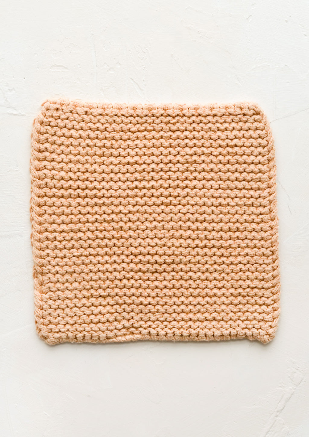 Nougat: A square, chunky knit cotton potholder in soft peach color.