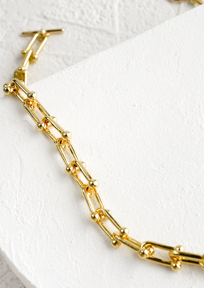 A chunky chainlink necklace in gold with toggle closure.
