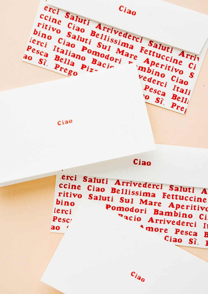 Stationary set of white folded cards with "Ciao" in red text and coordinating envelopes with allover Italian text