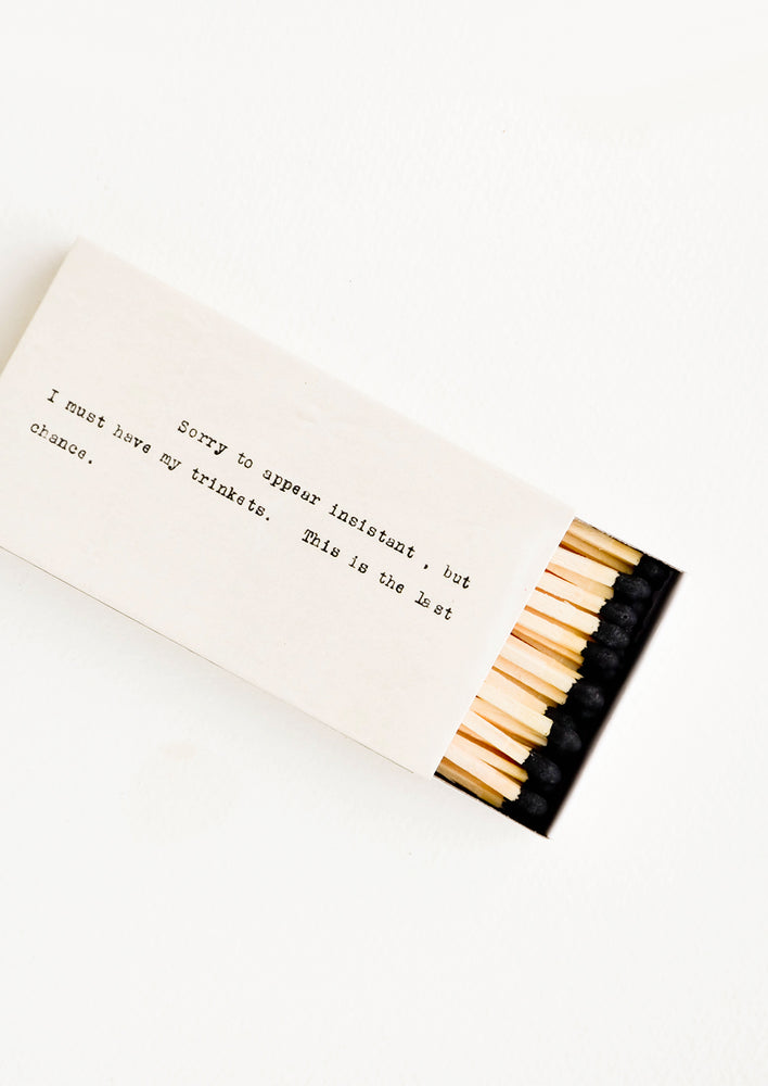 Long matches with black tips in matchbox printed with courier text