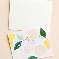 1: Greeting card with pastel scene of sliced and whole citrus fruits, with white envelope