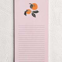 1: A light pink lined notepad with two oranges at the top