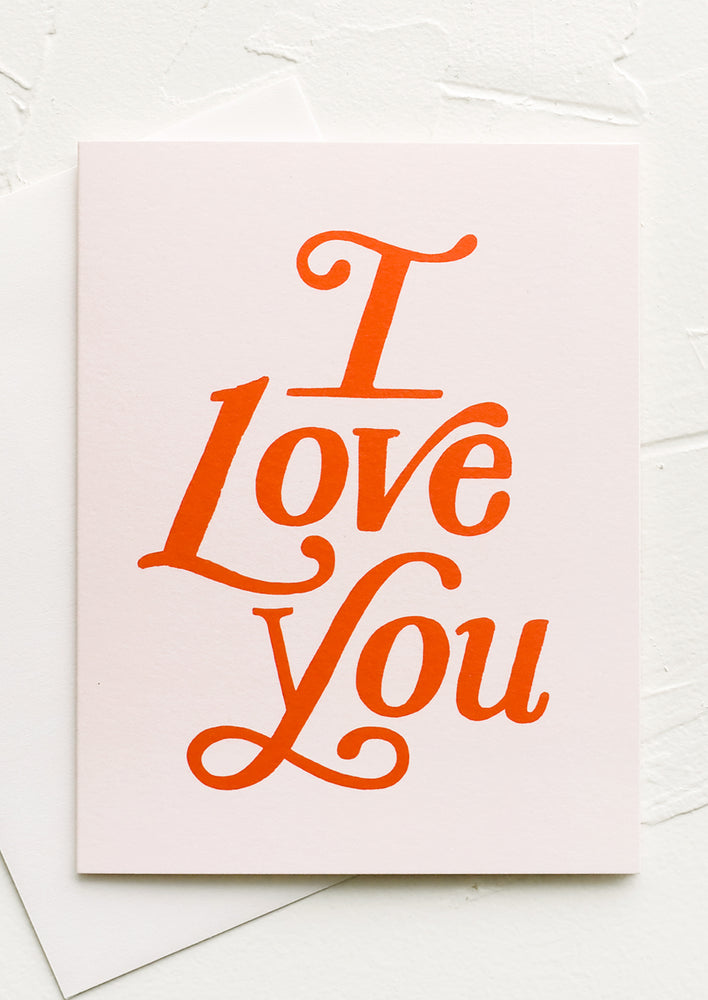 A pale pink greeting card with red text reading "I Love you".