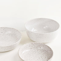 2: A mix of speckled white ceramic bowls in varied sizes.