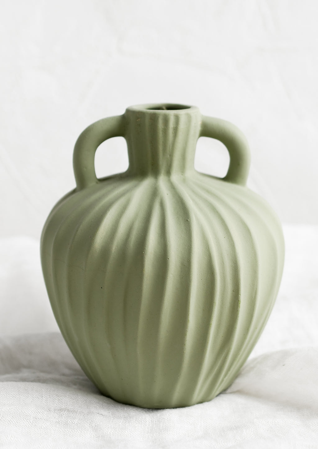 2: A mint green ceramic vase with handles at sides and carved line texture.