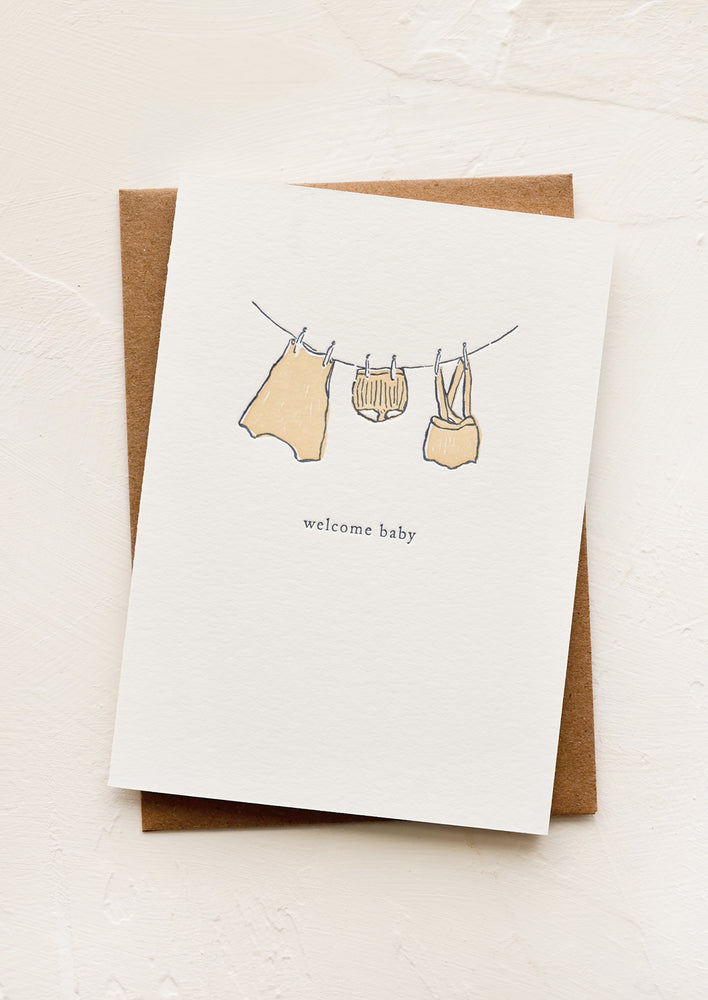 1: A greeting card with baby clothes hung on a clothesline.
