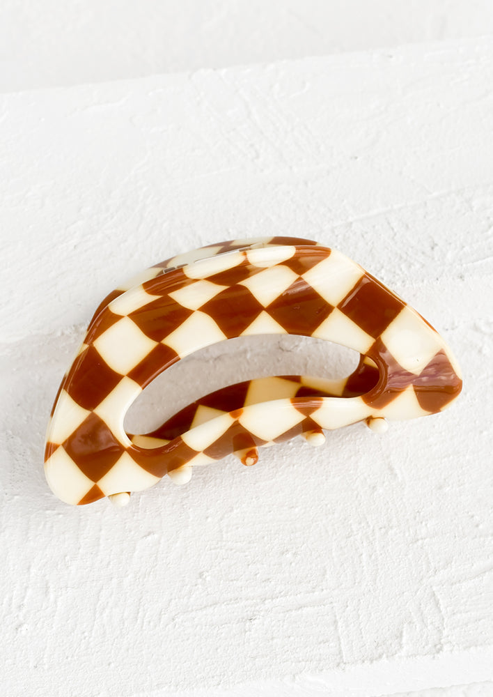 A cloud shaped hair claw in brown and white checker print.