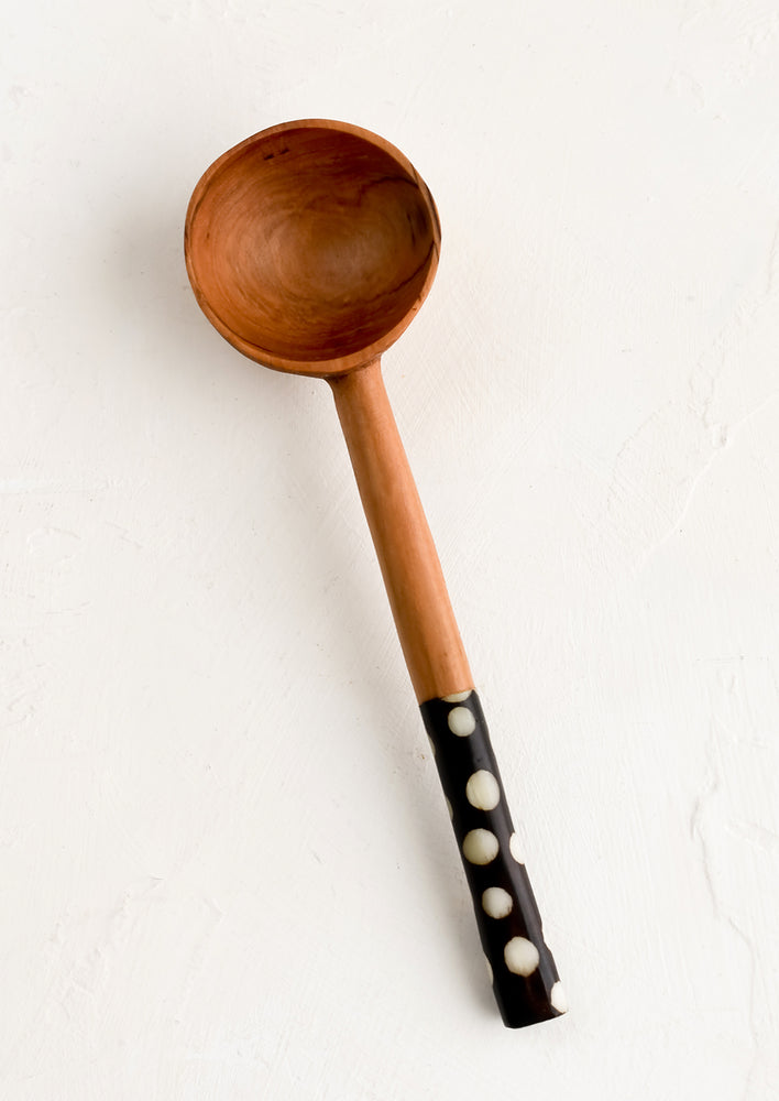 An olivewood coffee scoop with black and white printed bone handle.