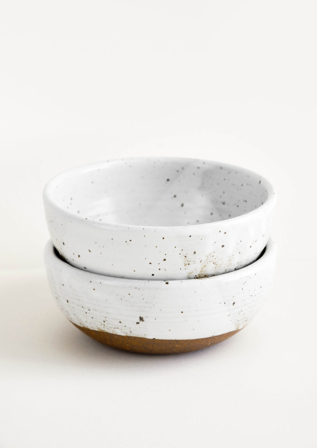 Glossy White / Soup: Two stacked white ceramic bowls with brown speckles.