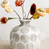 White Multi: A round vase with narrow neck, in white with grey polka dot print.