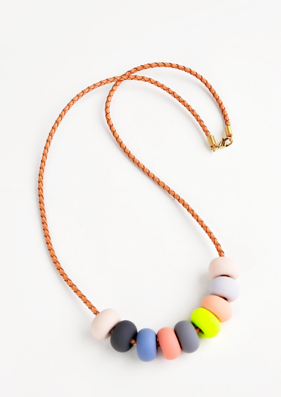 Woven leather cord necklace with gold clasp and rounded clay beads tans, pinks,gray, blue, and neon yellow.