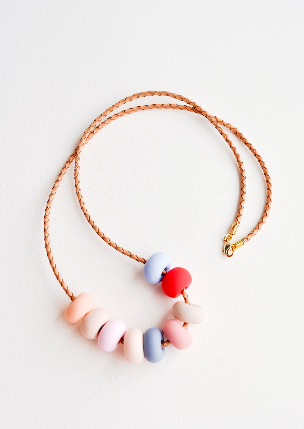 Desert Rose: Woven leather cord necklace with gold clasp and rounded clay beads tans, pinks, red, and blues.