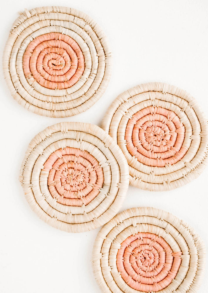 Blossom: Set of four round raffia coasters with natural rim and pink colored center