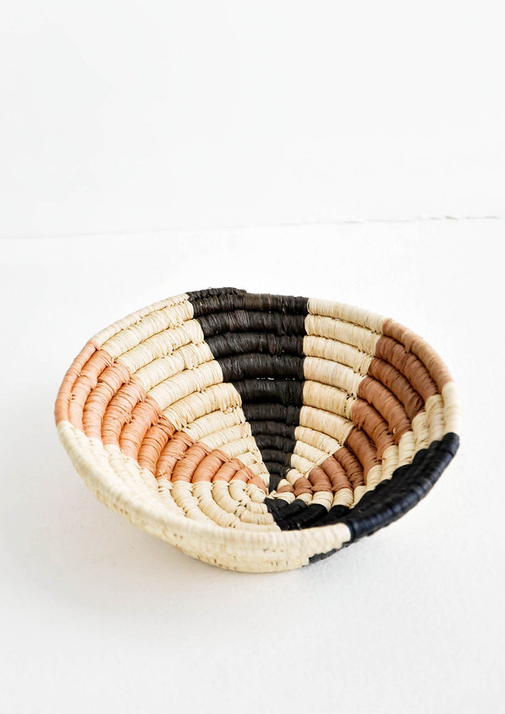 1: Small woven bowl made from natural fiber, multicolored "ray" pattern in neutral hues
