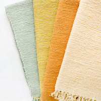 1: Cotton flatweave rug in solid color with slight texture, fringe trim on two ends