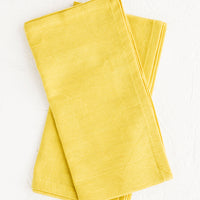 1: Pair of folded cotton napkins in chartreuse hue