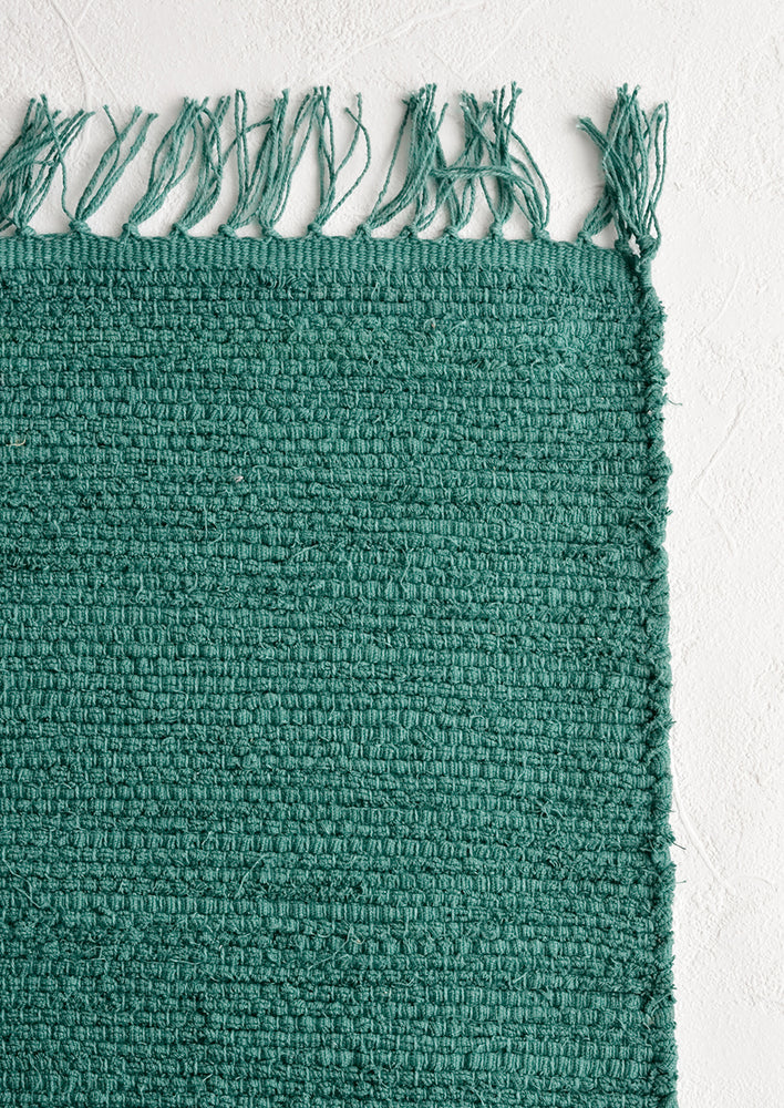 A textured cotton rug in bottle green.