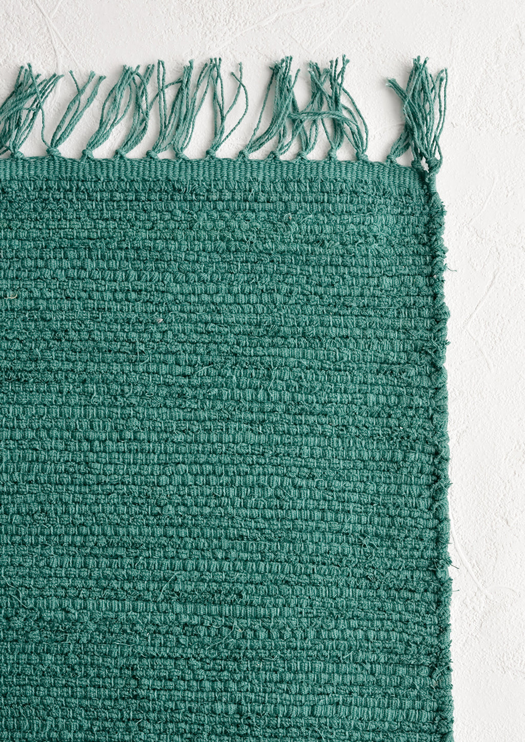 Aegean: A textured cotton rug in bottle green.