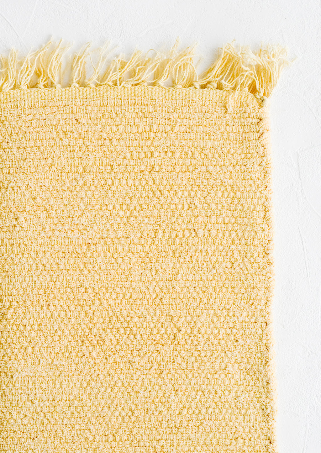 Maize: A textured cotton rug in light yellow.