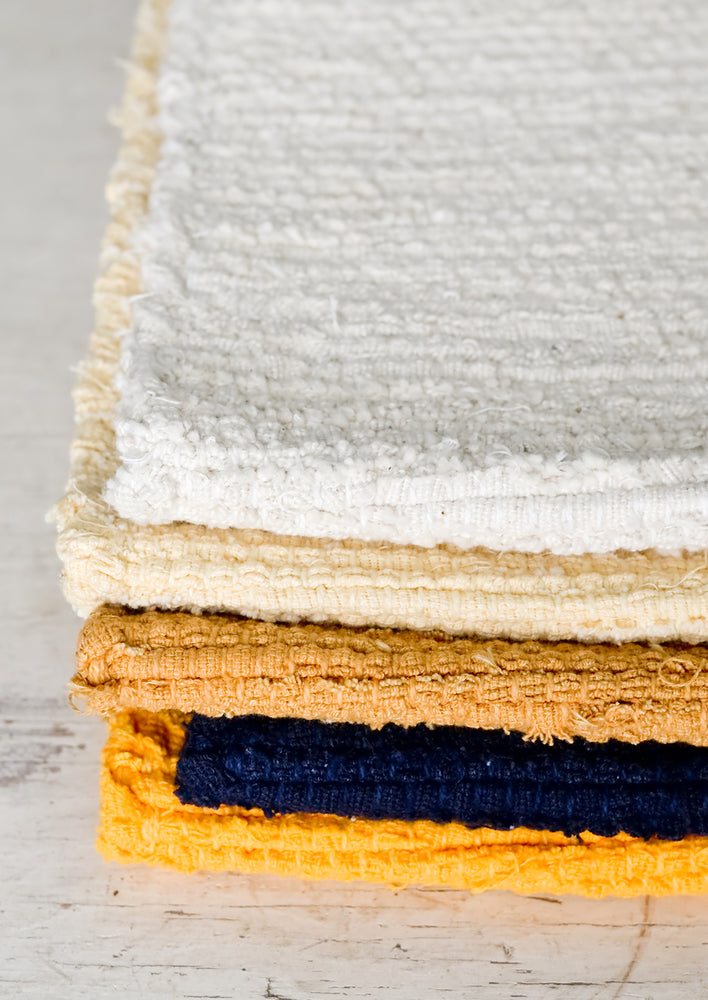 Navy: A stack of textured rugs.