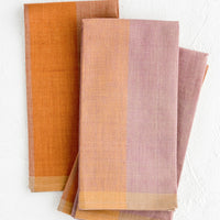 1: A stack of fabric napkins in purple and orange colorblock design.