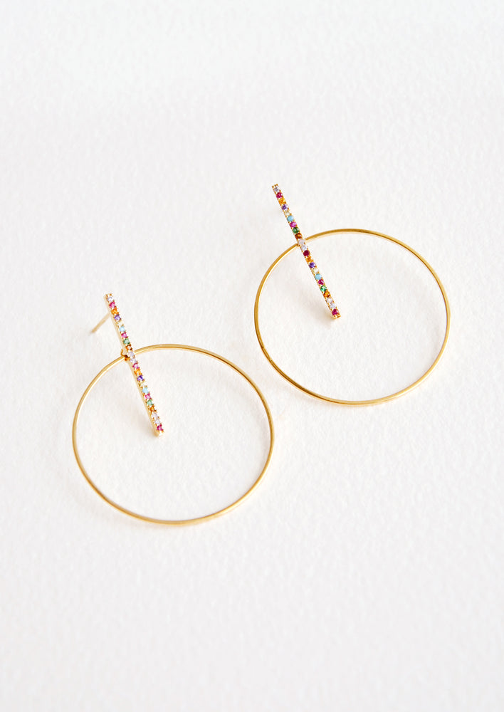 Round gold circle earrings with post across center of circle, featuring colored crystals