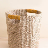 Mustard: An octogonal natural basket with mustard wrapped cutout handle.