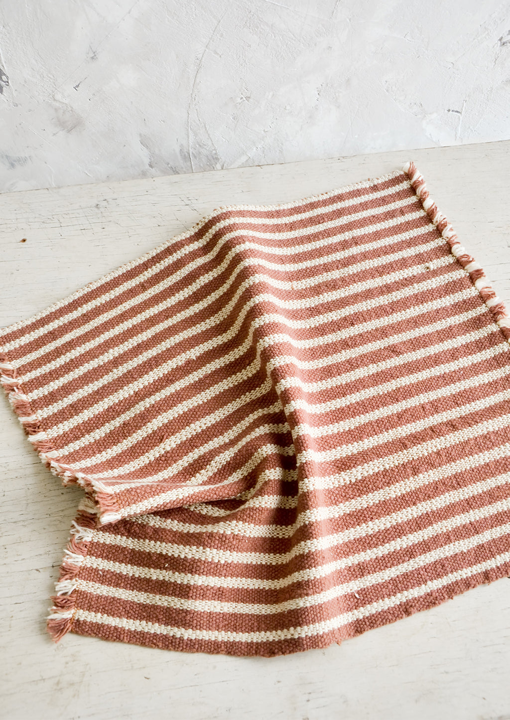 Terracotta / Beige: Natural cotton placemat with frayed edges in terracotta with beige stripes