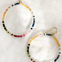 Muted Multi: A pair of beaded hoop earrings in assorted multi colors.