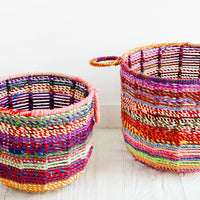 1: Round, circular storage bin made from colorful recycled fabrics woven together, featuring round handles at top.