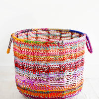 2: Round, circular storage bin made from colorful recycled fabrics woven together, featuring round handles at top.