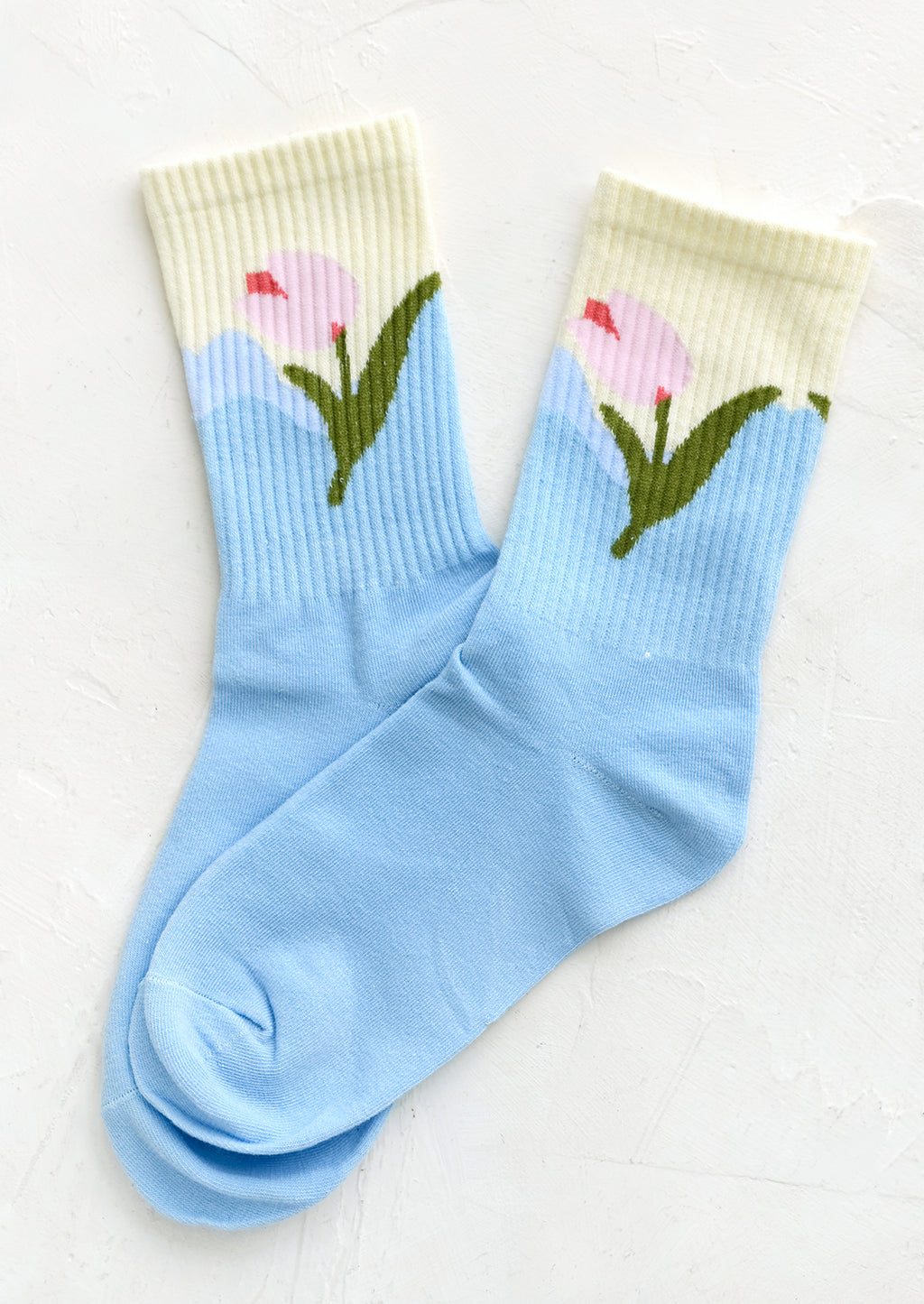 Sky Blue: A pair of socks in sky blue with pink tulip design at ankle.