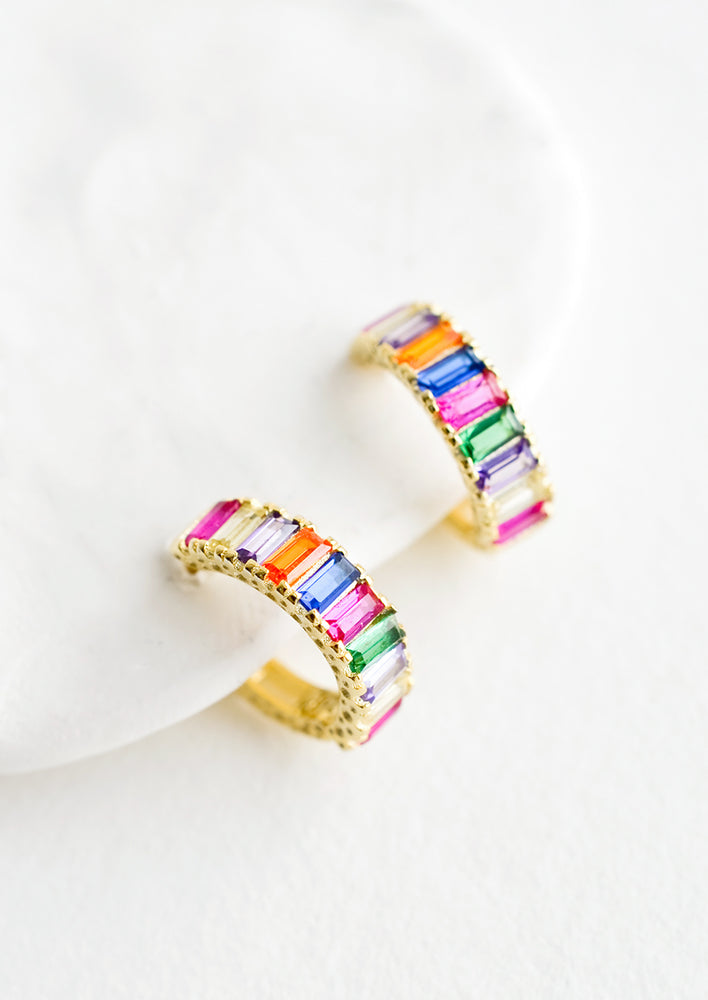 Gold hoop earrings with rectangular faceted rainbow colored gems.