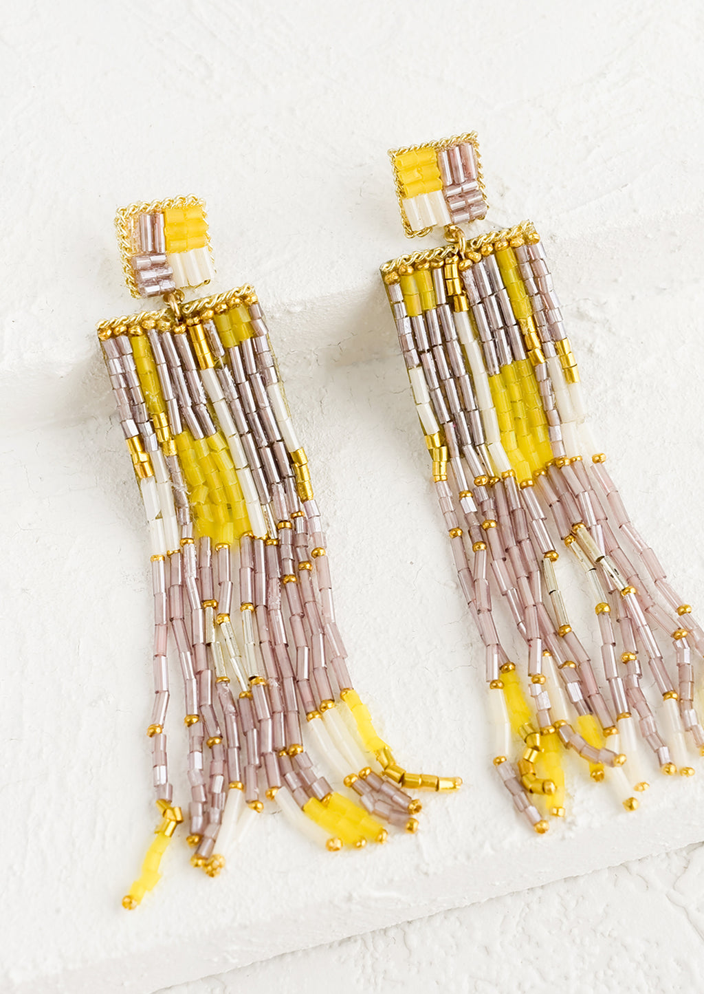 Yellow Multi: A pair of long beaded earrings in metallic mauve, white and yellow.