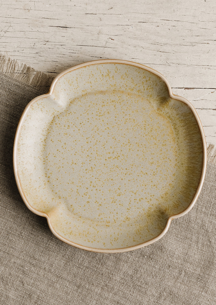 A quartrefoil shaped ceramic plate in pale lichen.