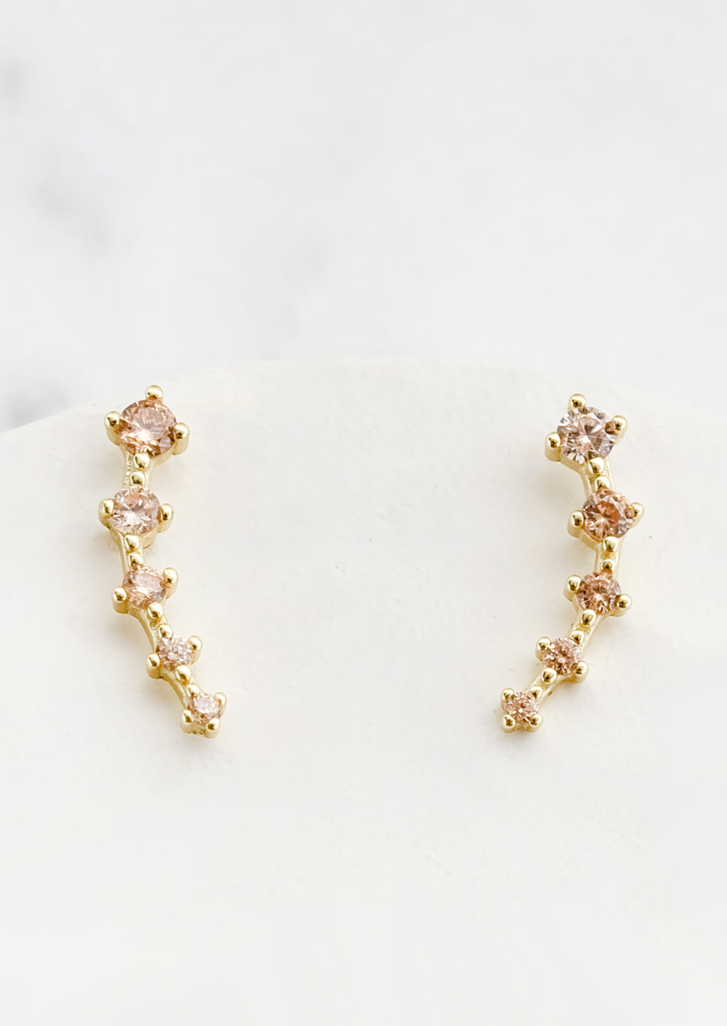 Champagne: Stud earrings with champagne crystals in incremental sizes, designed to climb up the ear