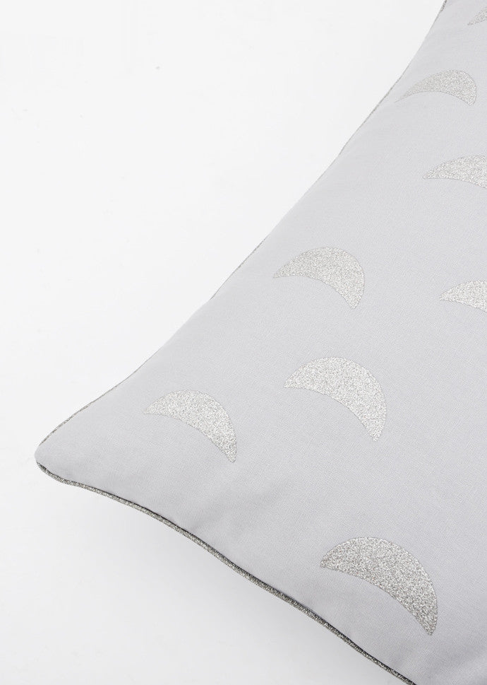 Grey linen blend throw pillow with silver glitter moon print on front, trimmed in metallic silver piping